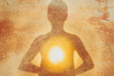 Female silhouette radiating light from within a spiritual heart opening.